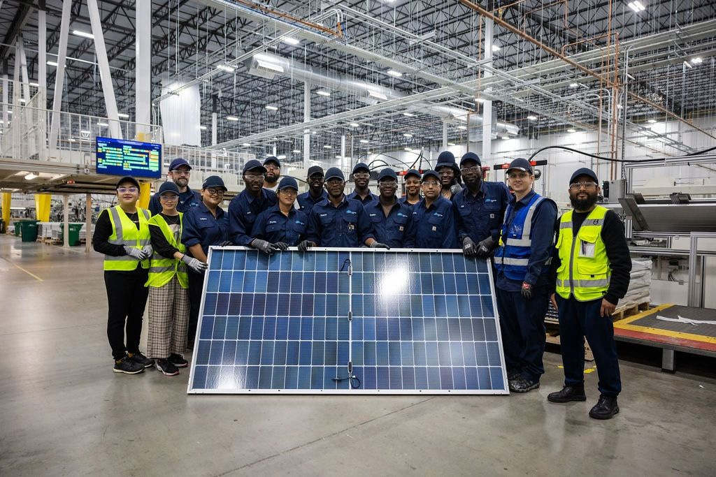Workers stand behind a solar panel at the Illuminate USA factory in Pataskala, Ohio. Workers stand behind a solar panel at the Illuminate USA factory in Pataskala, Ohio.